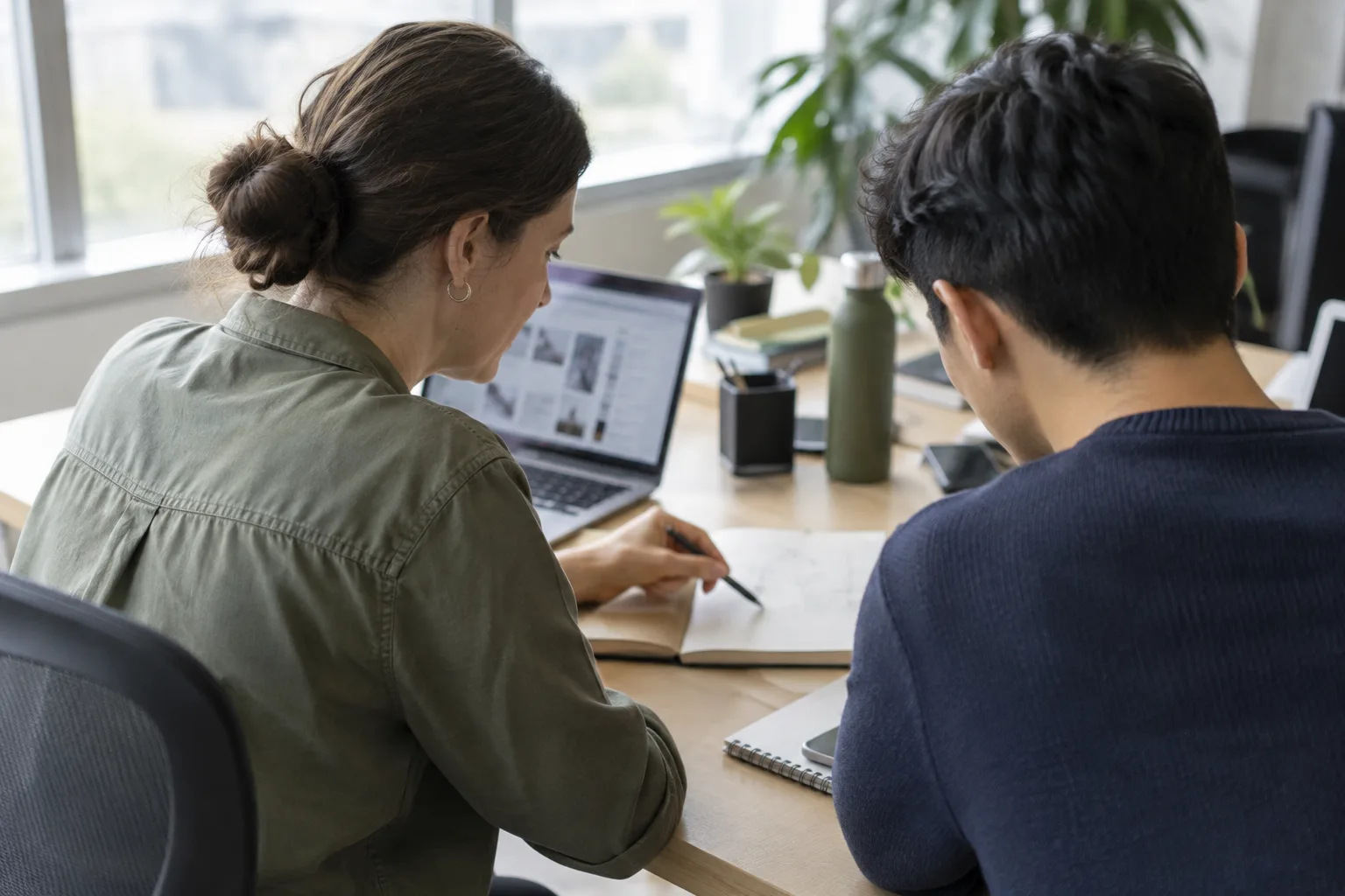 Une personne expérimentée montre à une nouvelle collègue comment réaliser une tâche de travail.