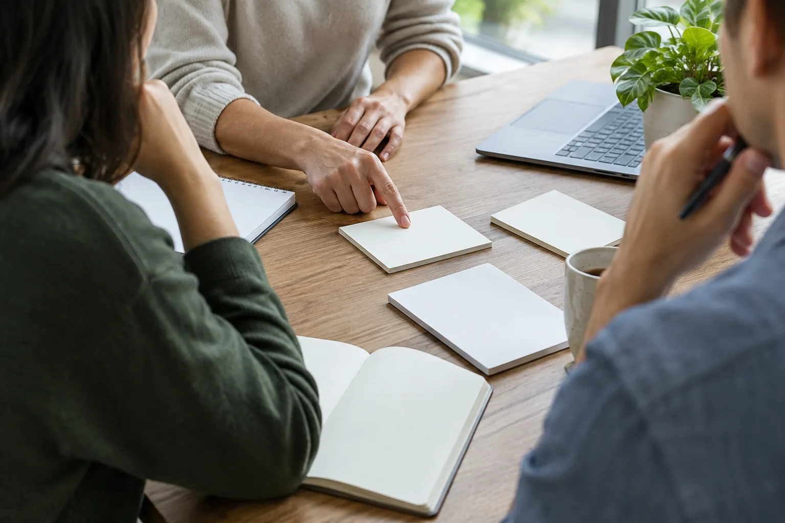 Des membres d’une équipe examinent ensemble des notes lors d’un retour d’expérience.