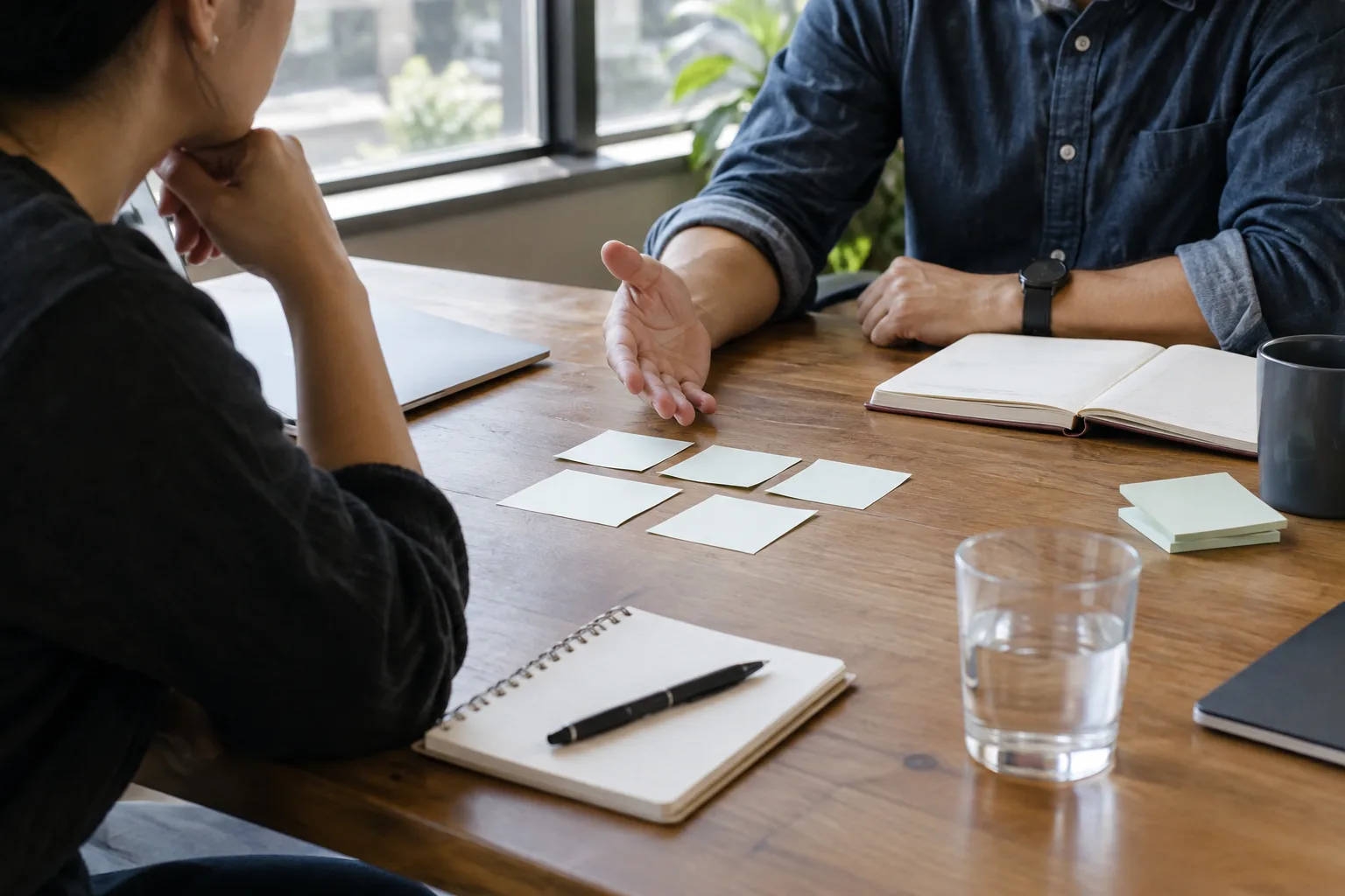 Des collègues discutent d’un essai de nouvelles règles de travail autour d’une table.