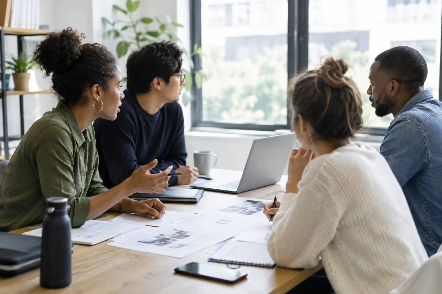 Des collègues examinent ensemble les étapes d’une tâche sur une table de travail.