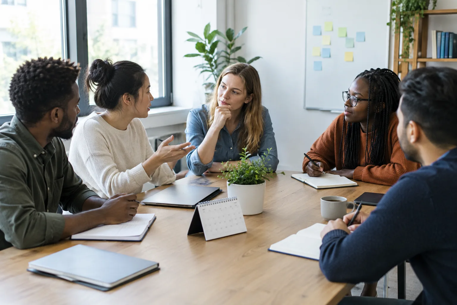 Des collègues échangent autour d’une table pour clarifier les priorités de travail.