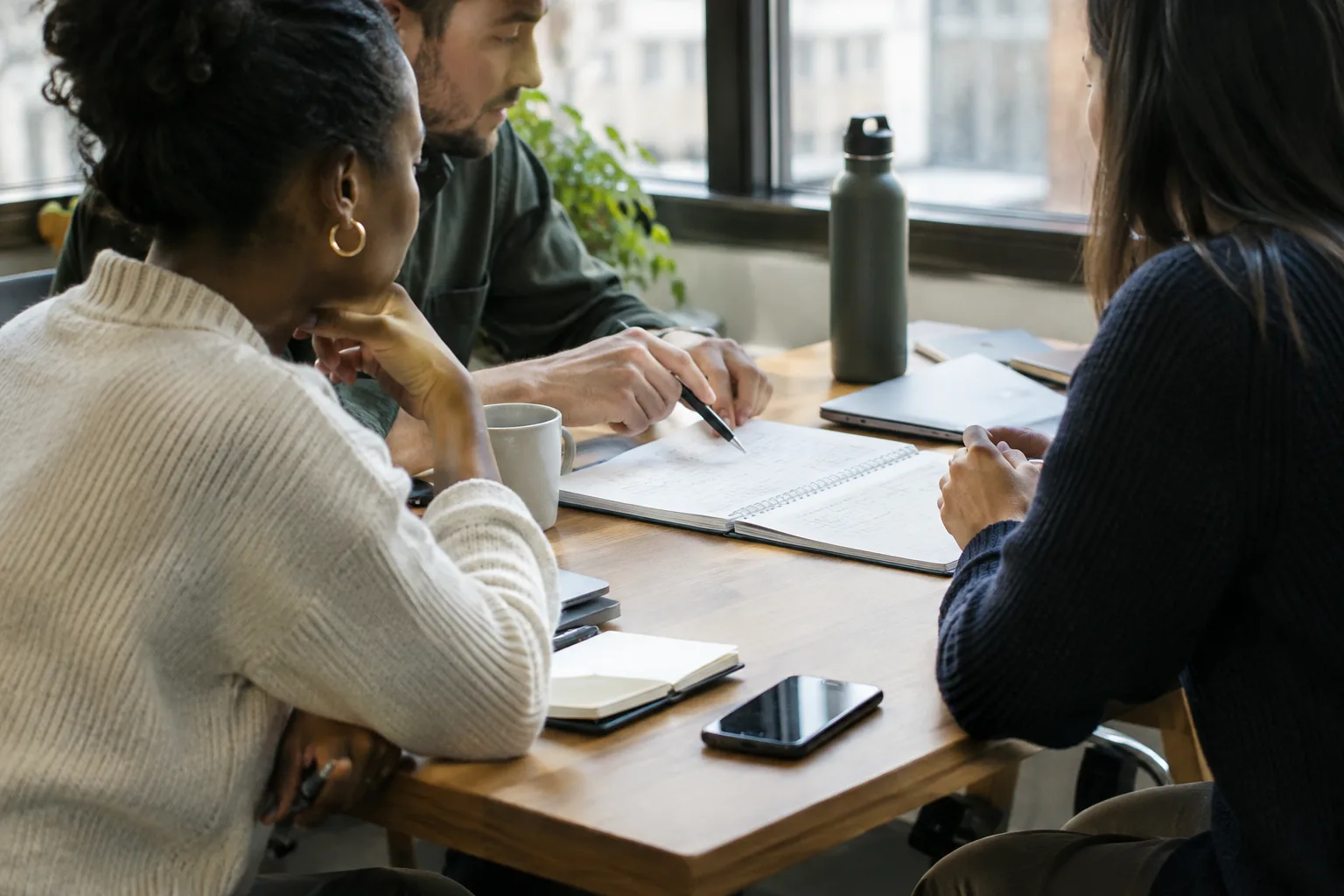 Des collègues consignent les prochaines actions d’équipe dans un carnet partagé.