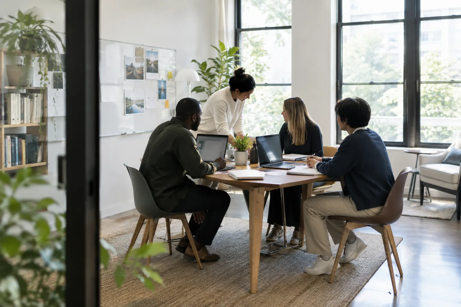 Des collègues échangent autour d’une table dans un espace de travail lumineux.